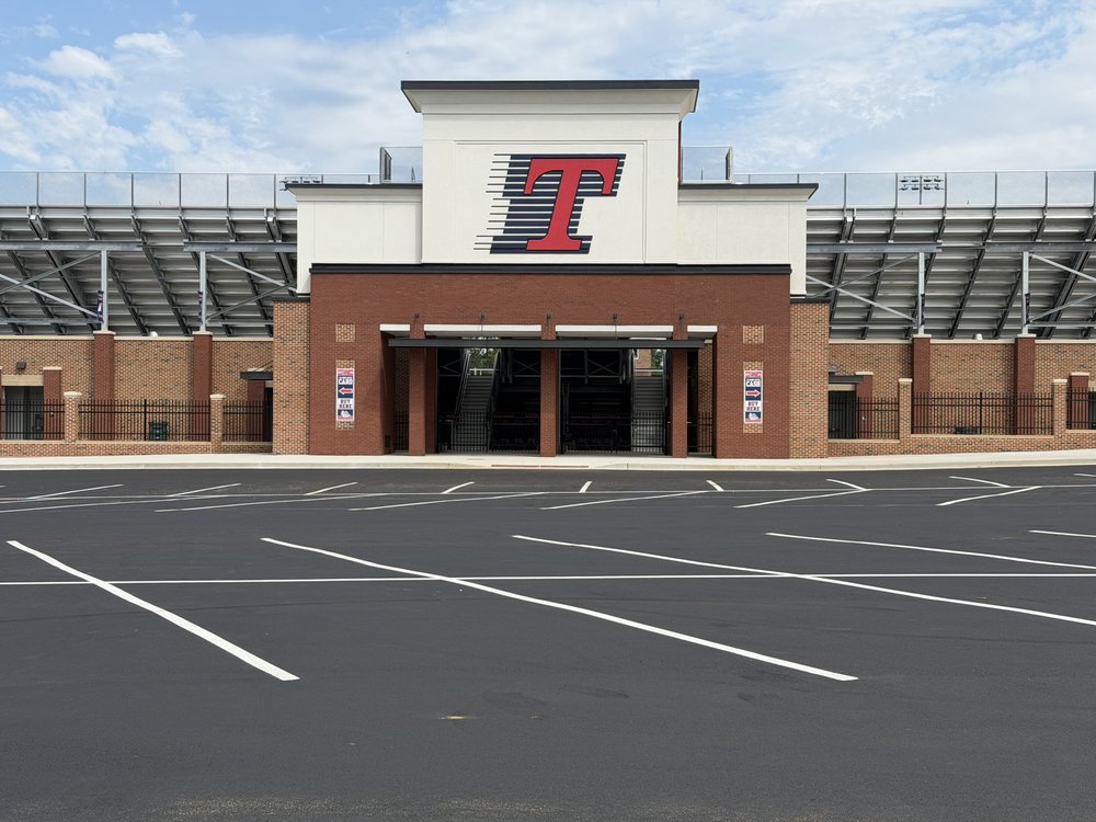 The brick and white Booster Stadium entrance with a large Flying T above its gates.