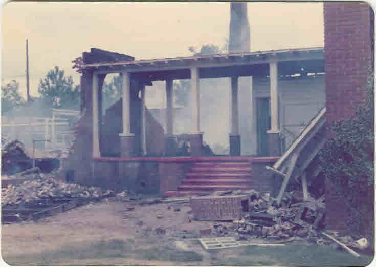 Steps and a standing covered entrance surrounded by fallen bricks and fire debris.