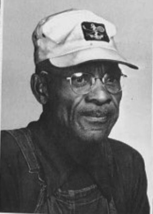 Portrait of Otis Phillips wearing a cap and overalls.