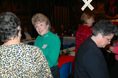 Marilyn Smith and Kathleen carry on a lively discussion while Margie Hadden reminisces at the photo table.
